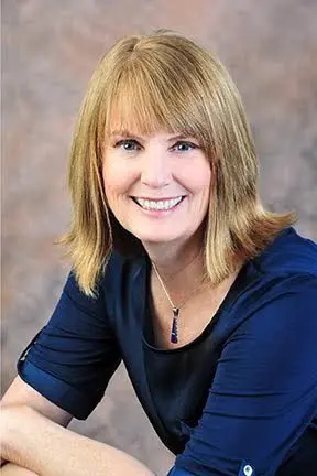 Julie Uhernik, smiling, in a navy top