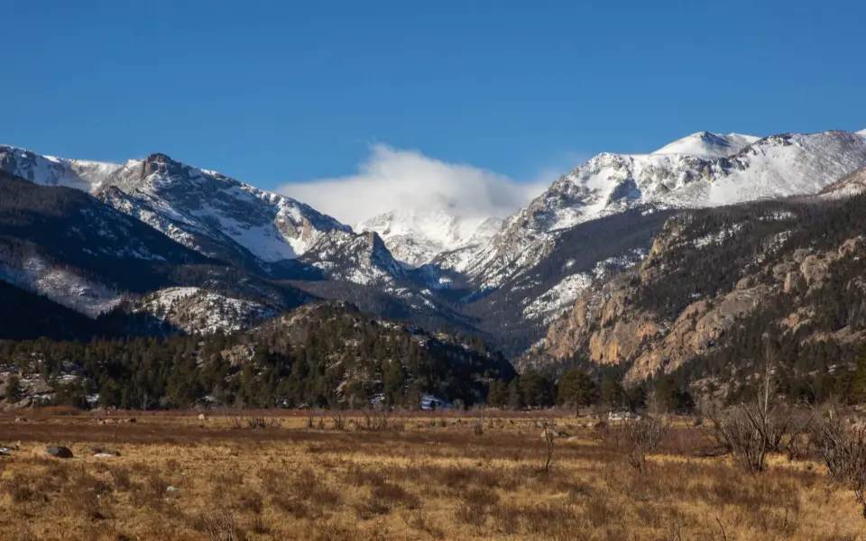 A wide meadow beneath snow-dusted peaks in Rocky Mountain National Park